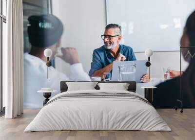 Mature supervisor having a meeting with his team in an office Wall mural