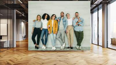 Multicultural businesspeople standing against a wall in an office Wall mural