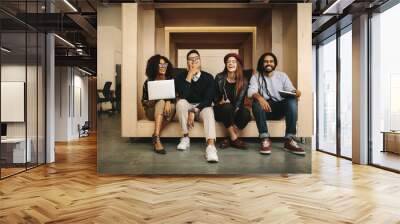 Office mates relaxing during work sitting together in a wooden e Wall mural