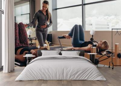 Pilates instructor training women at the gym Wall mural