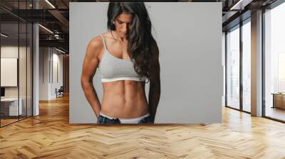 Powerful athletic woman wearing unzipped jeans Wall mural