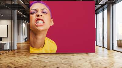 Quirky young woman making a face in a studio Wall mural