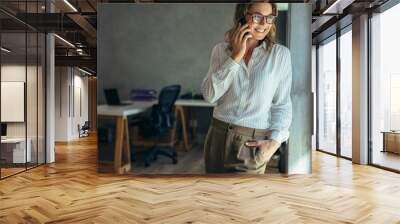 Relaxed businesswoman talking on cell phone Wall mural