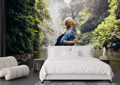 relaxed female hiker standing by the stream Wall mural