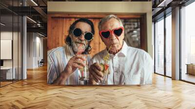 Retired men wearing funny sunglasses drinking juice Wall mural