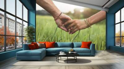 Romantic couple holding hands in a field Wall mural