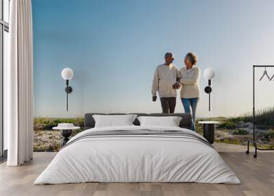 Romantic senior couple walking down a foot bridge at the beach Wall mural