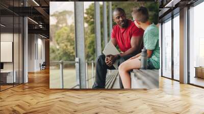 School coach talking a young student while sitting outside Wall mural