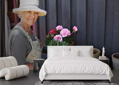 Senior woman planting flowers in a pot Wall mural