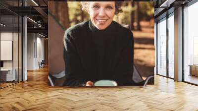 Senior woman sitting outside the tent with a cup of coffee Wall mural