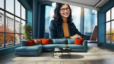 Smiling business woman in casuals at office Wall mural