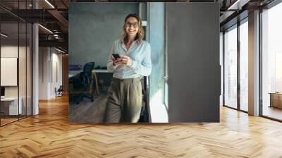 Smiling businesswoman at work in office Wall mural