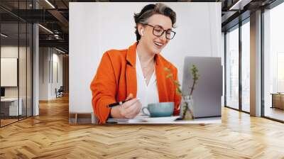 Smiling businesswoman having a virtual meeting while working in a cafe Wall mural