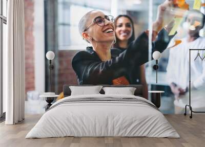 Smiling businesswoman sharing her ideas with her colleagues Wall mural