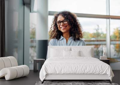 Smiling businesswoman standing in office Wall mural