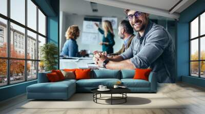 Smiling designer sitting in conference room Wall mural