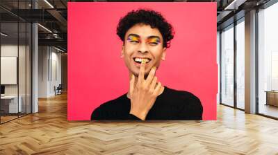 Smiling gay man with rainbow eye shadow and smiley nailpaint Wall mural