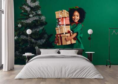 Smiling kid holding a pile of gift boxes Wall mural