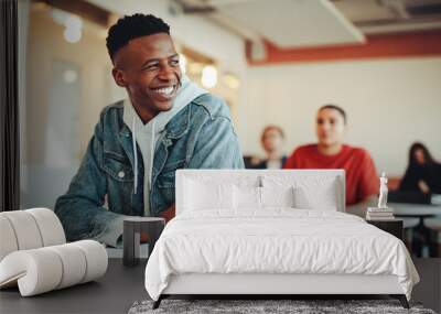 Smiling male student sitting in university classroom Wall mural