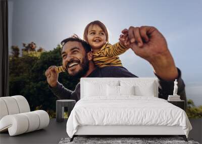 Smiling man playing with his kid outdoors Wall mural