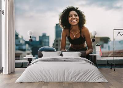 Smiling woman athlete taking a break during workout Wall mural