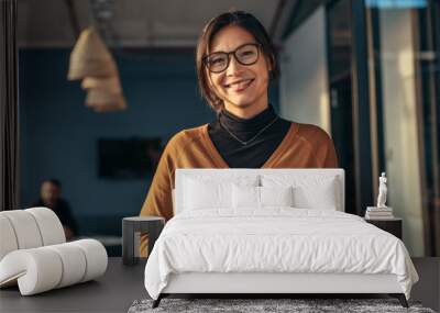 Smiling woman in casuals in office Wall mural