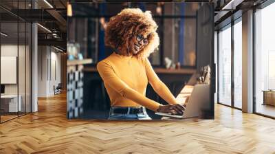 Smiling woman on a video call sitting at a coffee shop Wall mural