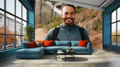 smiling young male runner on country road Wall mural