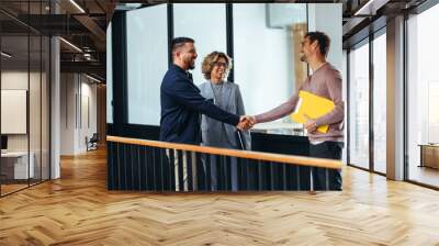 Successful business men shaking hands over a promotion in an office Wall mural