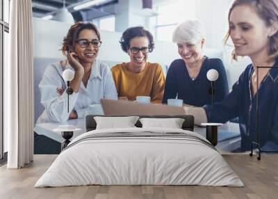 team of female professionals in cafeteria with a laptop Wall mural