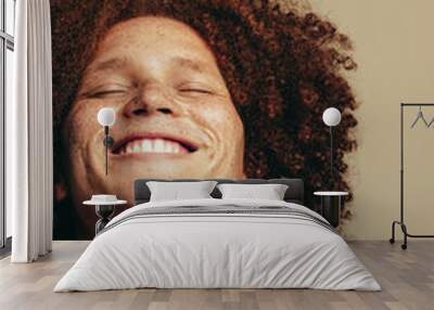 The joy of self-love: Young man with freckles and ginger hair smiles in a studio Wall mural