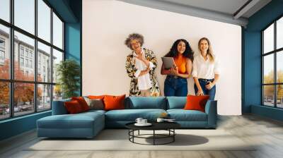 Three happy businesswomen laughing together Wall mural