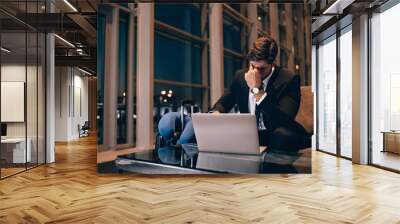 tired businessman waiting for delayed flight in airport lounge Wall mural