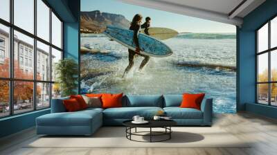 To young surfers going for water surfing Wall mural