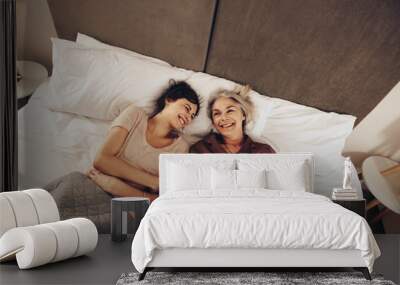 Top view of happy daughter and mother lying on bed at home Wall mural