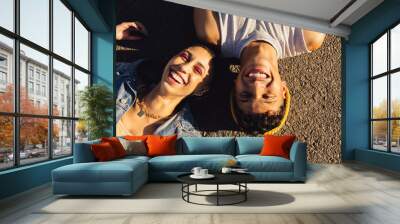 Top view of two friends lying down outdoors Wall mural