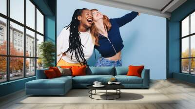 Two happy best friends laughing and having a good time while embracing each other Wall mural