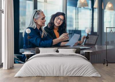 Two women analyzing documents at office Wall mural