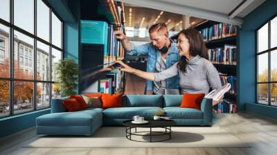 Two young students at library book shelf Wall mural