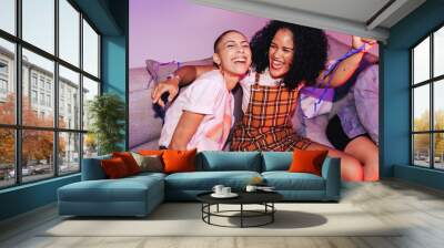 Vibrant female friends having a good time at a house party Wall mural