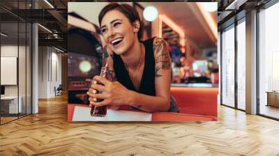 Woman at a restaurant holding a soft drink Wall mural