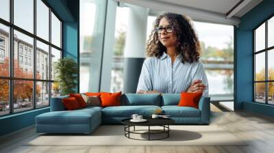 Woman entrepreneur standing at office window Wall mural