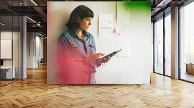 Woman holding digital tablet in office Wall mural