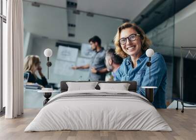 Woman sitting in board room during business meeting Wall mural