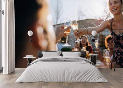 Woman toasting champagne with friend at party Wall mural