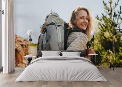 Woman with backpack hiking in nature Wall mural