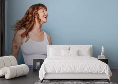 Woman with ginger hair dancing and having fun in a studio Wall mural