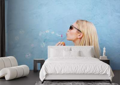 Young beautiful woman blowing soap bubbles Wall mural