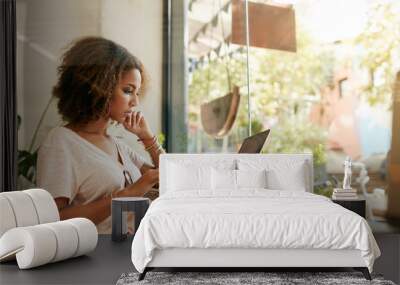 young black woman at cafe using laptop Wall mural