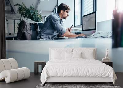 Young businessman in office working on computer Wall mural